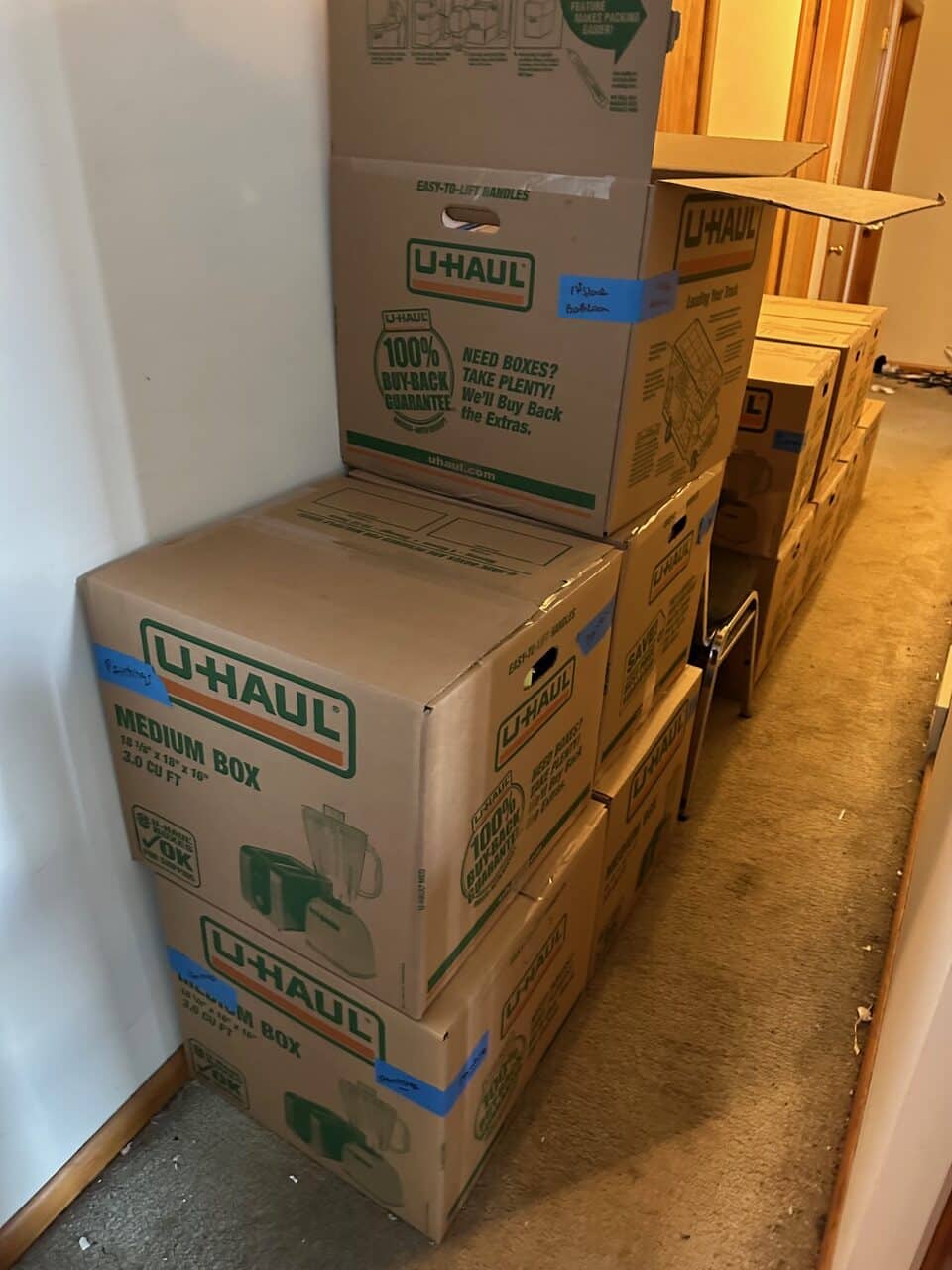 Stacked U-Haul moving boxes in a hallway during a Decluttering Chaos project in Ithaca, New York, showing organized packing and preparation for a smooth household move